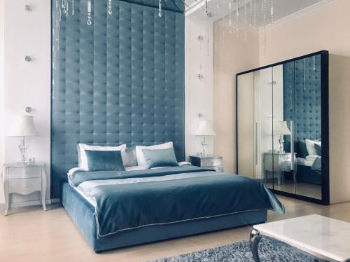 敖德萨Hotel Dom Aktera的一间蓝色的卧室,配有一张大床和镜子