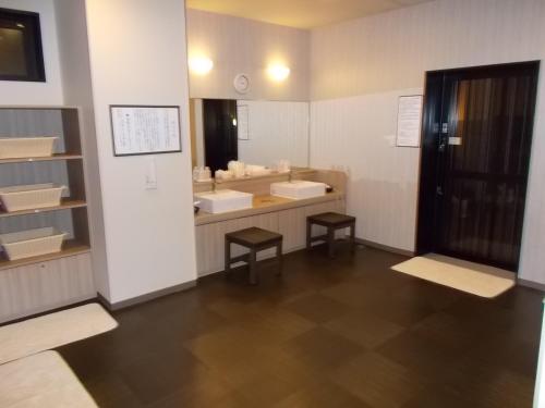 增田Hotel Route-Inn Masuda的一间带两个盥洗盆和大镜子的浴室