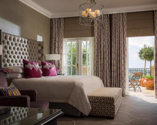 约翰内斯堡维斯特克里夫四季酒店的卧室配有一张带粉红色枕头的大床