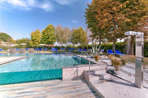阿巴诺泰尔梅贝尔索吉奥诺温泉酒店的一个带蓝色椅子和树木的大型游泳池