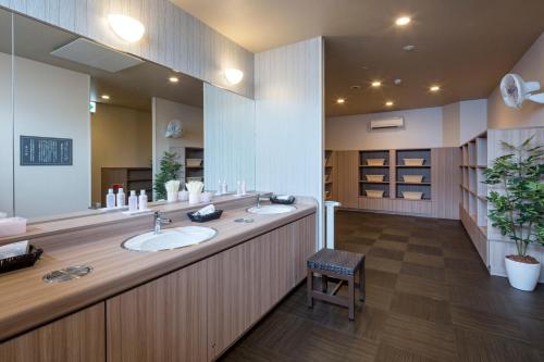 千叶HOTEL ROUTE-INN Chiba Hamano -Tokyowangan doro-的一间带两个盥洗盆和大镜子的浴室
