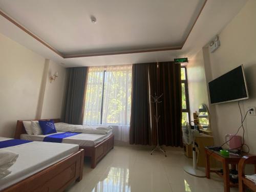 Cốc LếuVan Anh Motel的酒店客房设有两张床和电视。