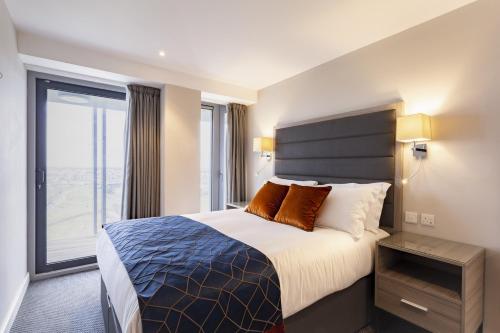 都柏林Metro Apartments Dublin Airport的酒店客房设有一张床和一个大窗户