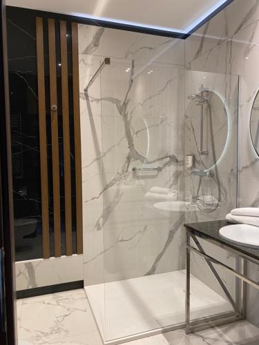 露米雅Hotel Falko的一间带玻璃淋浴和水槽的浴室