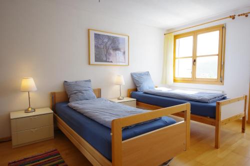 BrienzHaus Liaun 2的一间卧室设有两张床和窗户。