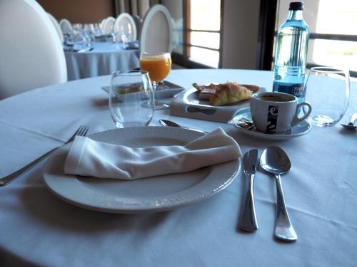 塞哥维亚Hotel ELE Acueducto的餐桌,饭盘,咖啡