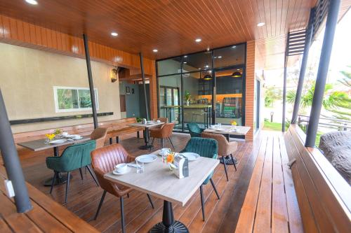 北冲Avarin Resort的一间铺有木地板并配有桌椅的餐厅