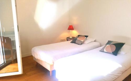 佩罗斯-吉雷克Appartement spacieux à 200 m de la plage - Hôtel de l'Europe的一间卧室配有两张床和镜子