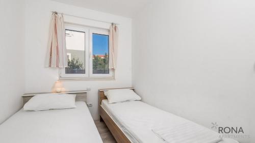 伊穆尼Rona Apartments Zlatko的带窗户的客房内的两张床