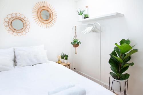 阿姆斯特丹Trendy 2 bedroom accommodation on perfect location的一间卧室配有床、镜子和植物