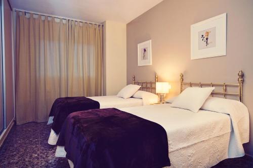 梅里达赛勒斯旅游公寓的酒店客房设有两张床和窗户。