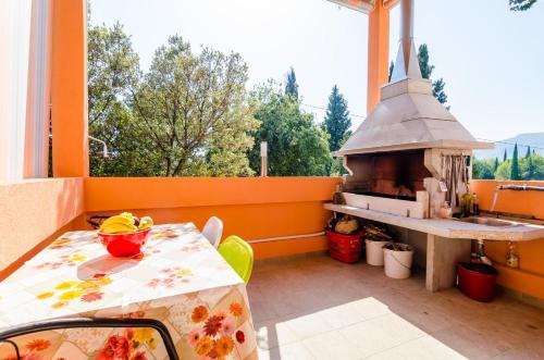 斯拉诺Apartments Donita的阳台配有桌子和比萨饼烤箱。