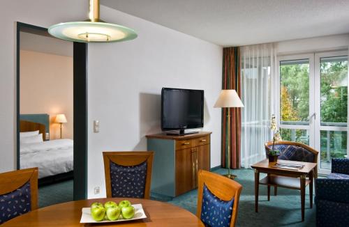 魏玛Congress Hotel Weimar by Mercure的酒店客房设有餐桌和电视。