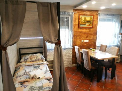 沙巴茨Vila Violeta的一间卧室配有一张床和一张桌子及椅子