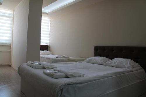 安卡拉阿布罗内卡提贝酒店的卧室配有一张带白色床单和枕头的大床。