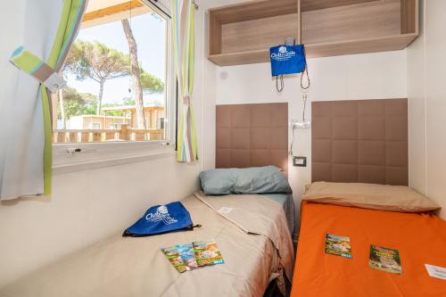 蓬他码头Adriano Family Camping Village的小房间设有两张床和窗户