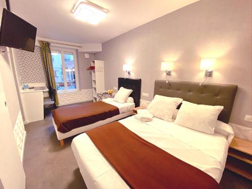 巴黎阿维亚迪克酒店的酒店客房设有两张床和电视。