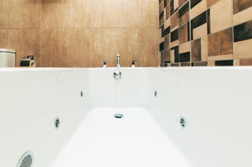 达累斯萨拉姆Blackwood Boutique Hotel and Apartments的一间带白色浴缸及两面水龙头的浴室