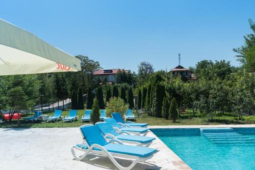 Băltenii de SusPensiunea Știuca Șchioapă的游泳池旁的一排蓝色躺椅