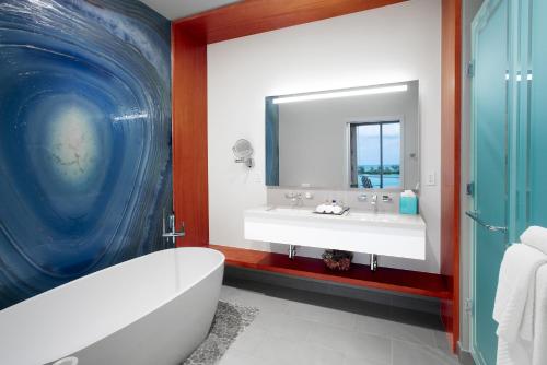 拿骚Margaritaville Beach Resort Nassau的带浴缸、水槽和镜子的浴室
