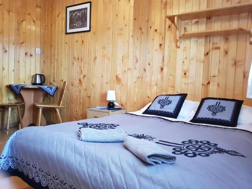 考斯赛力克Spanie po Zbóju的一间卧室配有一张带蓝色床单和木墙的床。