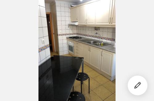 蒙蒂茹Wonderful apartament Lisbon的厨房配有白色橱柜和黑色台面