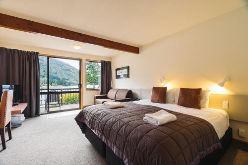瓦纳卡Hawea Hotel的酒店客房设有一张床和一个阳台。