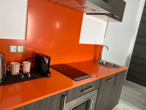 塞维利亚Apartamentos "El Escondite de Triana"的厨房配有橙色台面和电话