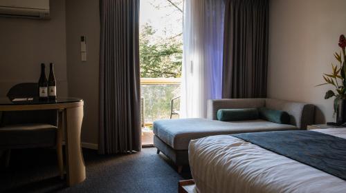 堪培拉Madison Capital Executive Apartments的酒店的客房 - 带一张床、椅子和窗户