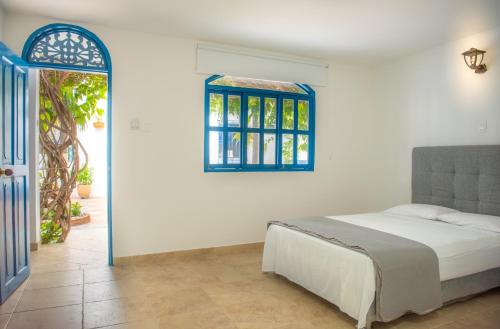 巴兰基亚卡萨加勒比殖民公寓的一间卧室设有一张床和一个窗口