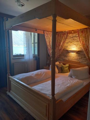 佩尔蒂绍西盆申纳盆霍夫旅馆的卧室配有带白色床单的天蓬床