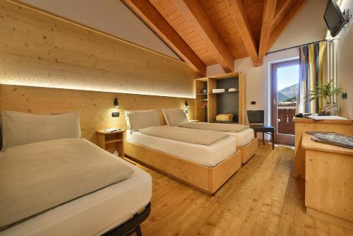 利维尼奥圣乔瓦尼酒店的一间卧室设有两张床和窗户。
