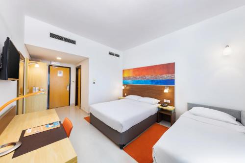 迪拜布尔迪拜城市马克斯酒店的酒店客房配有两张床和一张书桌