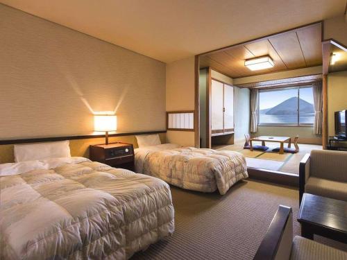 洞爷湖洞爷湖畔亭酒店的酒店客房设有两张床和大窗户。