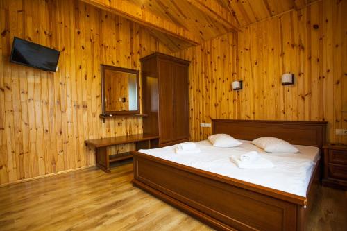 ZadonetskoyePark Rost Club的木制客房内的一间卧室,配有一张床