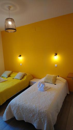 莱斯帕尔梅多克CAFE DE PARIS的黄色墙壁客房的两张床