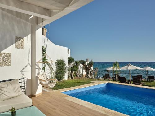 查加基恩Cavo Orient Beach Hotel & Suites的毗邻大海的别墅 - 带游泳池