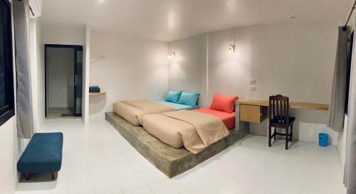 甲米镇Simple House Ao Nang - B&B的一间卧室配有一张床、一张桌子和一把椅子