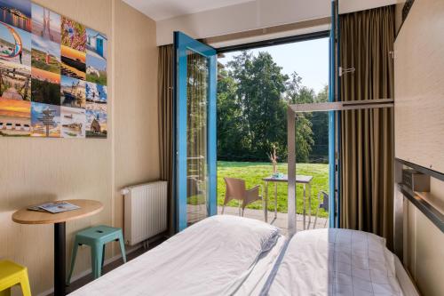 登堡Stayokay Hostel Texel的一间卧室设有一张床和一个大窗户
