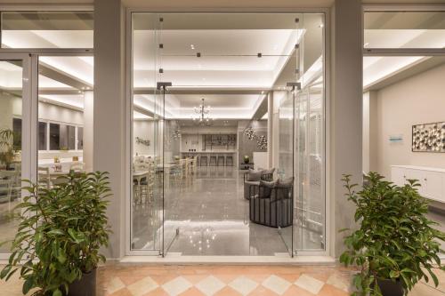 卡西奥皮Melina Oasis Boutique Hotel的大堂设有玻璃墙和盆栽植物