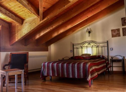 布尔戈斯Casa rural Ermita 1 y 2的一间卧室设有一张床和木制天花板