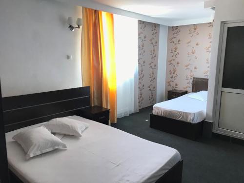 普洛耶什蒂Casa Ardeleană的酒店客房设有两张床和窗户。