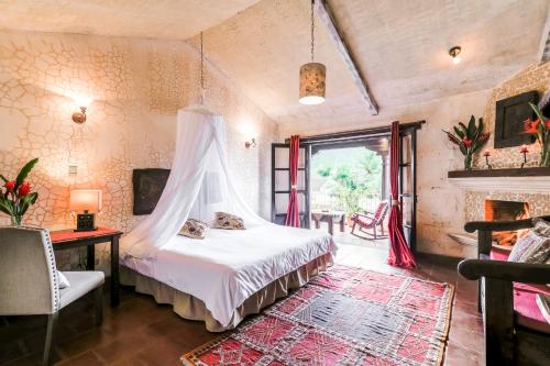 危地马拉安地瓜Casa Serenidad的一间卧室配有一张床和一个壁炉