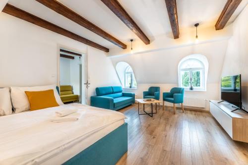 捷克克鲁姆洛夫Villa Wurmfeld的一间卧室配有一张床、两把椅子和一台电视