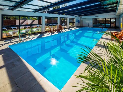 米尼亚卢博瓦尔Garrigae Manoir de Beauvoir Poitiers Sud - Hotel & Spa的蓝色海水大型游泳池