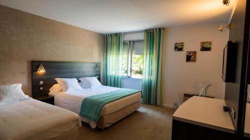 德龙河畔洛里奥勒Logis Hotel Restaurant SPA Les Oliviers的酒店客房设有两张床和窗户。