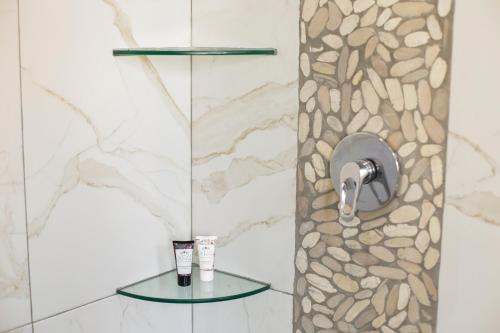坎昆Casa Korima Cancun - Luxurious - Budget Friendly的带淋浴的浴室(带石墙)