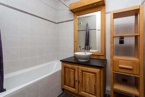 夏蒙尼-勃朗峰Le Paradis 15 Apartment - Chamonix All Year的浴室配有盥洗盆和浴缸。
