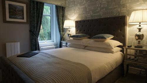 布莱尔高里Ivybank Lodge的卧室配有带枕头的大床和窗户。