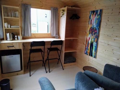 博克斯梅尔Langs De Maas的小屋内的客厅配有两把椅子和台面